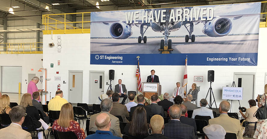 Assistant Secretary Dr. John C. Fleming speaks in front of a We Have Arrived signe after announcing $12.25 million EDA investment in the city of Pensacola, Florida