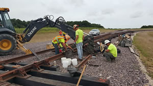 Workers construct new rail spur to facilitate shipping raw materials to manufacturing and distribution center.